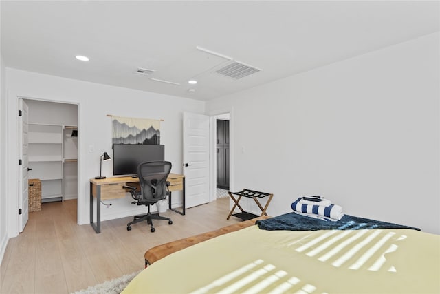 704 Emerald Wood Dr, Austin, TX 78745 - bedroom featuring light wood-style floors, a spacious closet, an office area, recessed lighting, and a closet