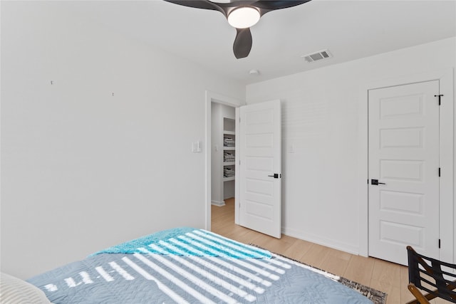 bedroom with light wood finished floors, baseboards, visible vents, and a ceiling fan