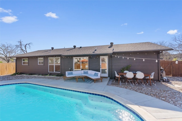 rear view of house featuring a patio, fence, and a fenced in pool