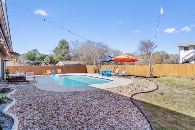 view of swimming pool featuring a fenced in pool, an outdoor living space, a patio area, and a fenced backyard