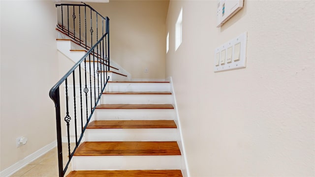 stairs featuring baseboards and tile patterned floors