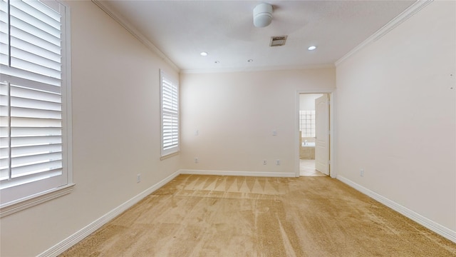 unfurnished room featuring baseboards, light colored carpet, visible vents, and crown molding