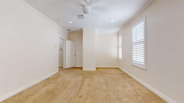 spare room with ornamental molding, visible vents, light carpet, and baseboards