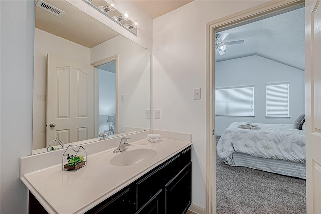 bathroom with ensuite bath, visible vents, vaulted ceiling, and vanity