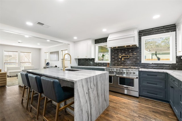 516 W 30th St, Houston, TX 77018 - kitchen with double oven range, a sink, custom exhaust hood, open floor plan, and light stone counters