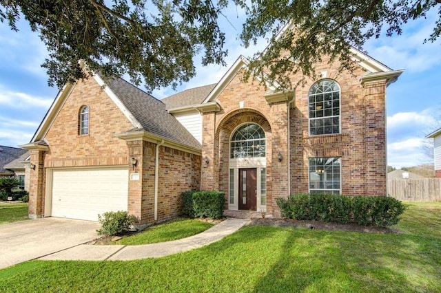 traditional home featuring a garage, a front yard, brick siding, and driveway