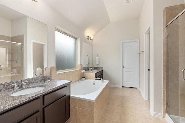 bathroom with lofted ceiling, a shower stall, two vanities, and a sink