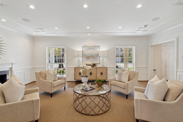 living area with a wealth of natural light, a wainscoted wall, a fireplace, and recessed lighting