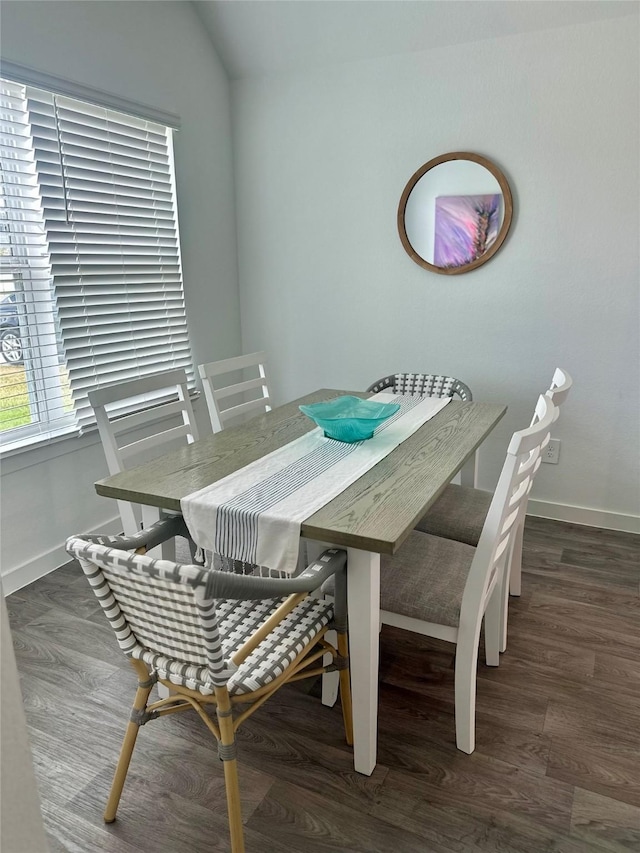 dining space featuring lofted ceiling, baseboards, and dark wood-type flooring