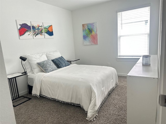 bedroom featuring dark colored carpet and baseboards