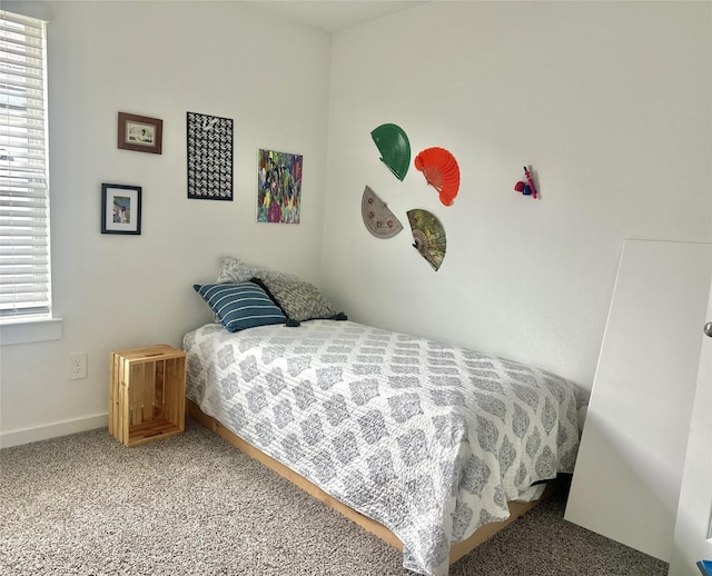 carpeted bedroom featuring multiple windows and baseboards