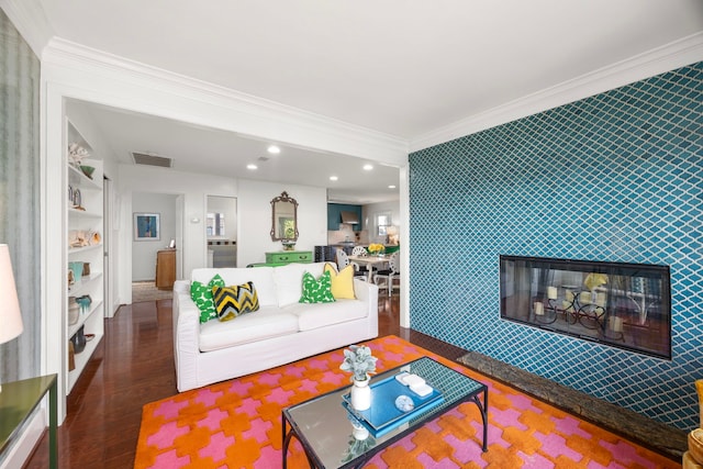 living room with crown molding, visible vents, an accent wall, wood finished floors, and wallpapered walls