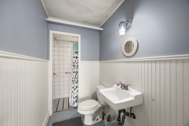 bathroom featuring wainscoting, a shower stall, and toilet