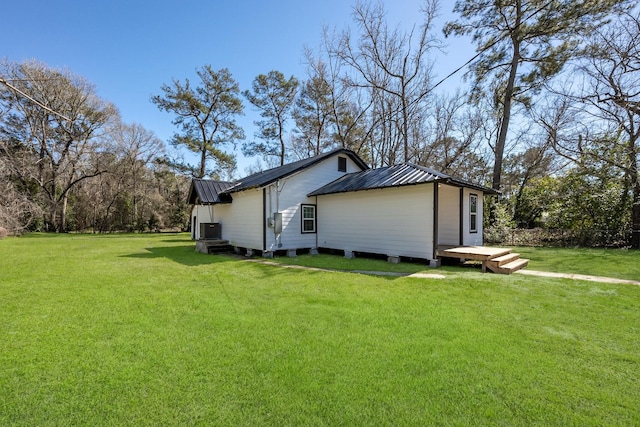 view of side of home with metal roof and a yard