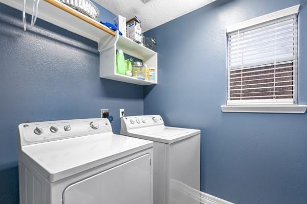 laundry area with washing machine and dryer, laundry area, and a textured ceiling