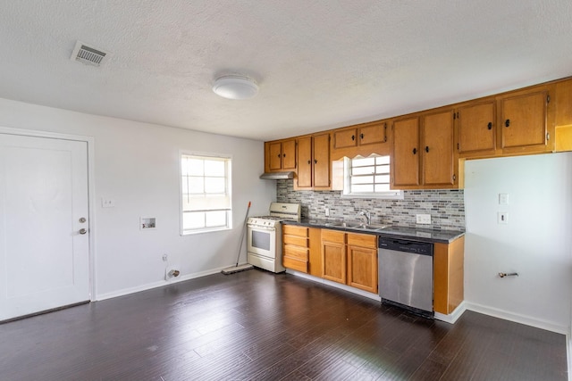 629 13th Ave N, Texas City, TX 77590 - kitchen featuring dark countertops, brown cabinets, stainless steel dishwasher, and white gas range oven