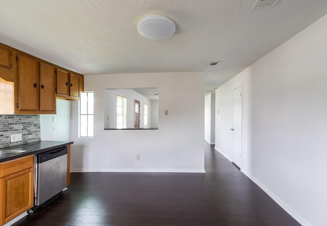 629 13th Ave N, Texas City, TX 77590 - kitchen with dark countertops, backsplash, brown cabinets, and dishwasher