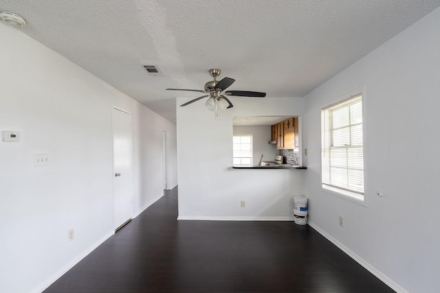 629 13th Ave N, Texas City, TX 77590 - unfurnished living room with ceiling fan, dark wood-type flooring, a textured ceiling, and baseboards