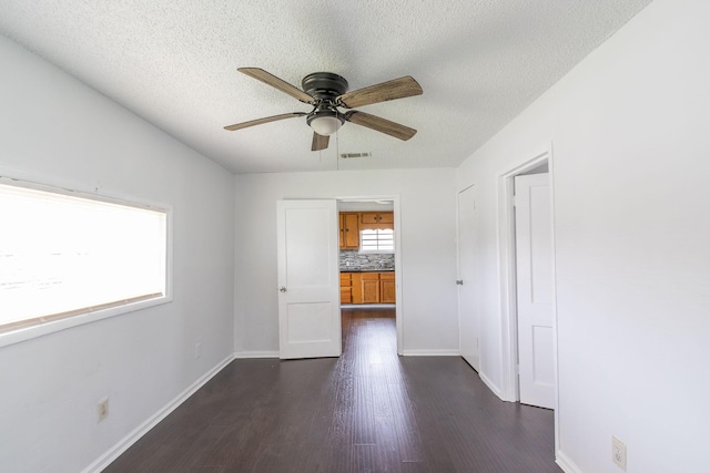629 13th Ave N, Texas City, TX 77590 - unfurnished room with dark wood-style floors, visible vents, ceiling fan, a textured ceiling, and baseboards