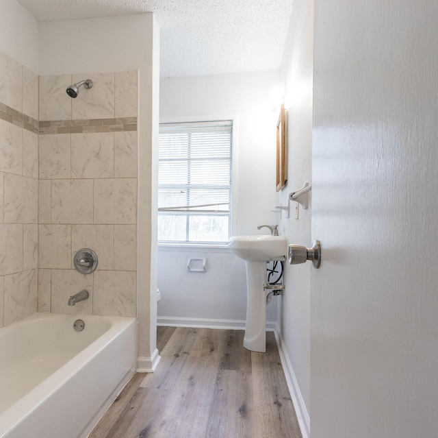 629 13th Ave N, Texas City, TX 77590 - full bathroom with washtub / shower combination, a textured ceiling, baseboards, and wood finished floors