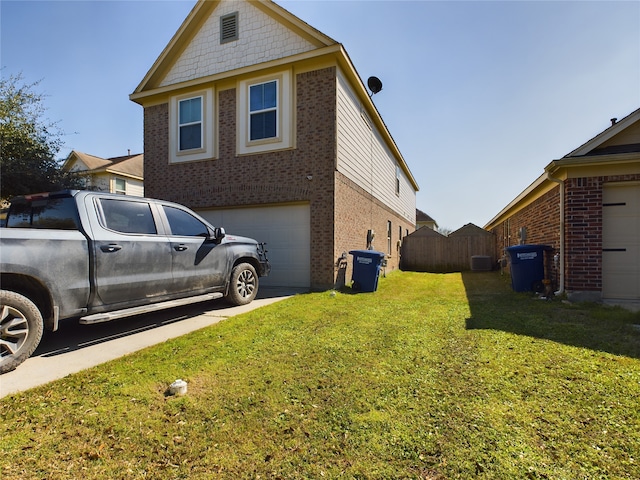 view of side of home with concrete driveway, fence, a lawn, and brick siding