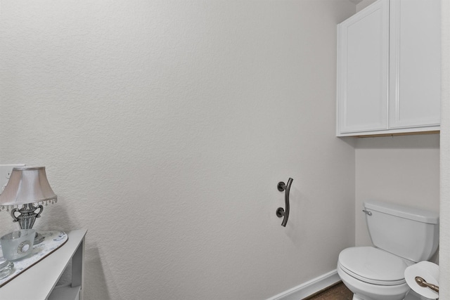 bathroom with toilet and baseboards