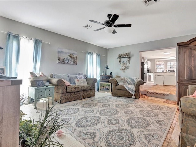 living area featuring visible vents and ceiling fan