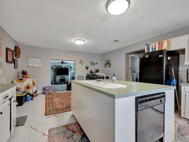 kitchen with light countertops, white cabinetry, a sink, and an island with sink