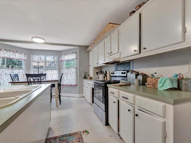 kitchen with finished concrete flooring, baseboards, white cabinetry, and stainless steel electric stove