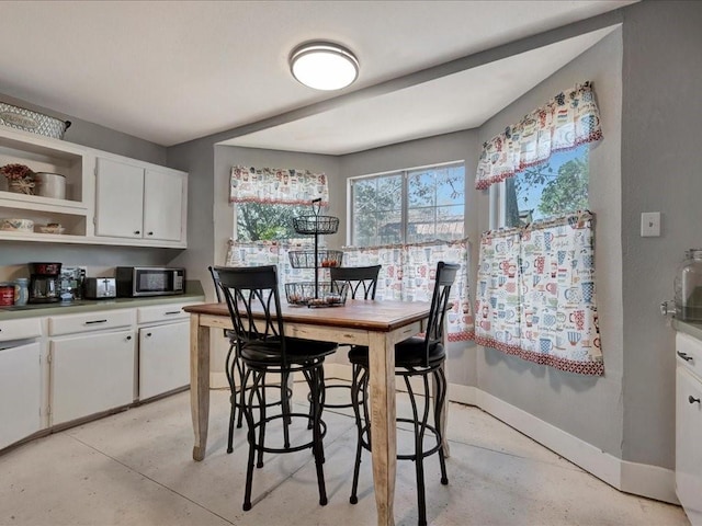 dining room featuring baseboards and concrete flooring