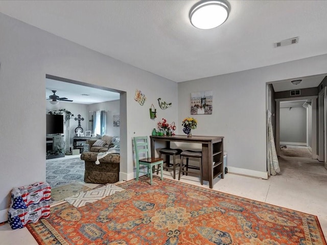 interior space featuring a ceiling fan, visible vents, and baseboards