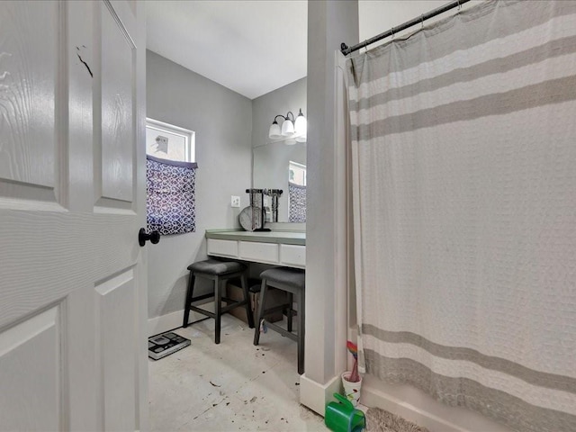 bathroom with concrete flooring, shower / bath combo, and baseboards