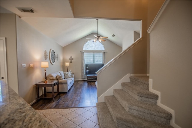 interior space featuring visible vents, lofted ceiling, a ceiling fan, and stairs