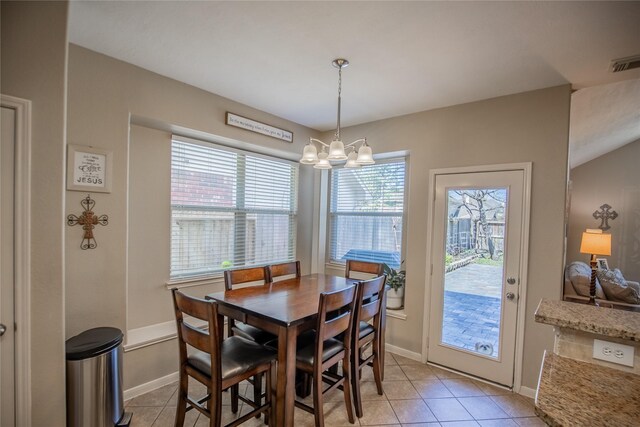 dining area featuring light tile patterned floors, visible vents, a chandelier, and baseboards