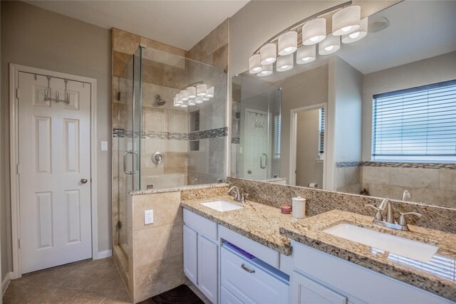 full bathroom with tile patterned floors, a shower stall, double vanity, and a sink