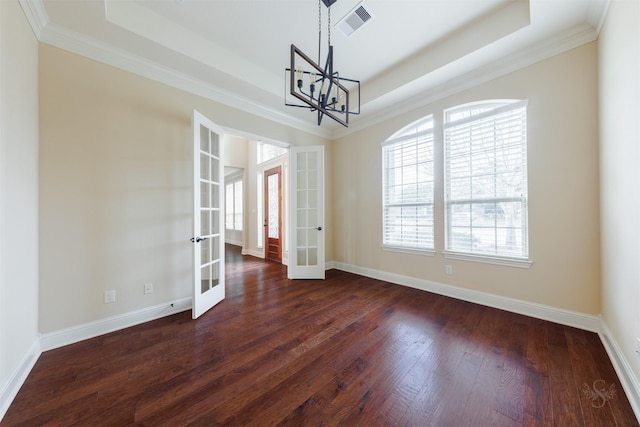 unfurnished dining area with baseboards, a tray ceiling, dark wood-type flooring, and french doors