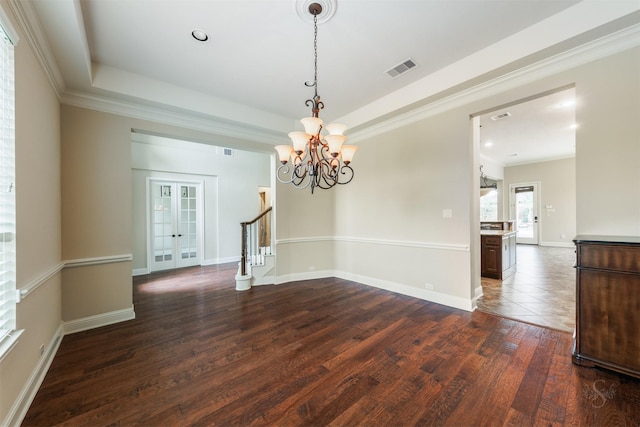 empty room featuring ornamental molding, a raised ceiling, dark wood-style flooring, and french doors