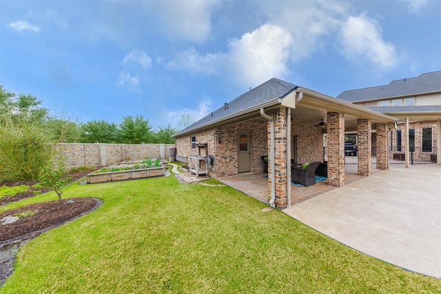 view of yard with a patio area, a fenced backyard, a fireplace, and a vegetable garden