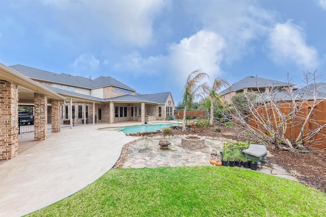 view of pool featuring a fire pit, a patio, a lawn, and a fenced backyard