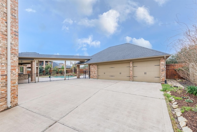 view of front of home featuring brick siding, a shingled roof, concrete driveway, fence, and a garage