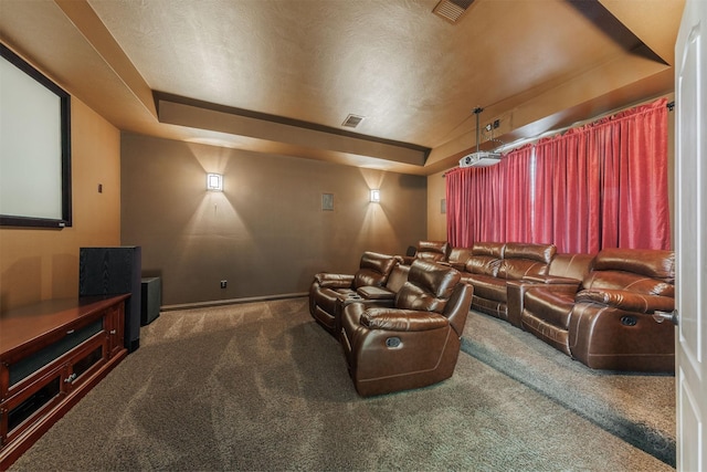 carpeted cinema room with a raised ceiling, visible vents, a textured ceiling, and baseboards