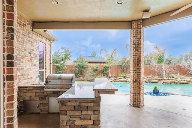 27711 Rocky Creek Ct, Fulshear, TX 77441 - view of patio / terrace featuring a grill, an outdoor kitchen, a fenced backyard, and a fenced in pool