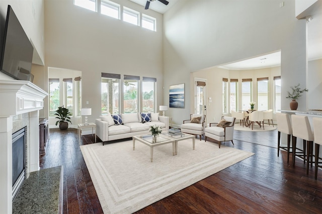 living room featuring dark wood-style flooring, a healthy amount of sunlight, and a fireplace