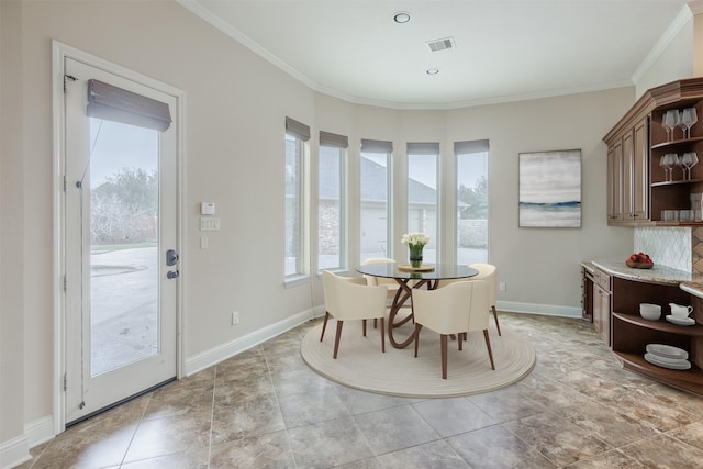 dining room with light tile patterned floors, baseboards, visible vents, and crown molding