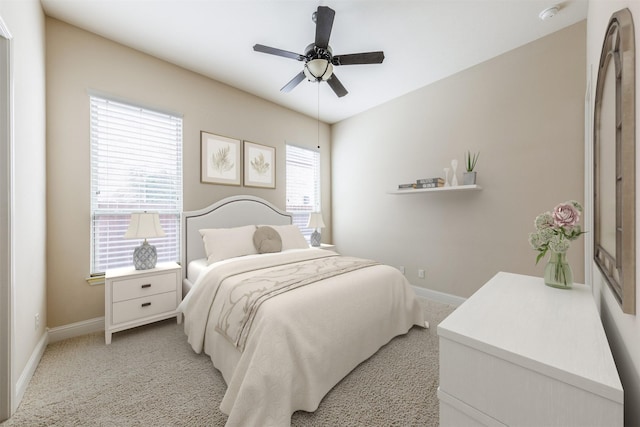 bedroom with light carpet, ceiling fan, and baseboards