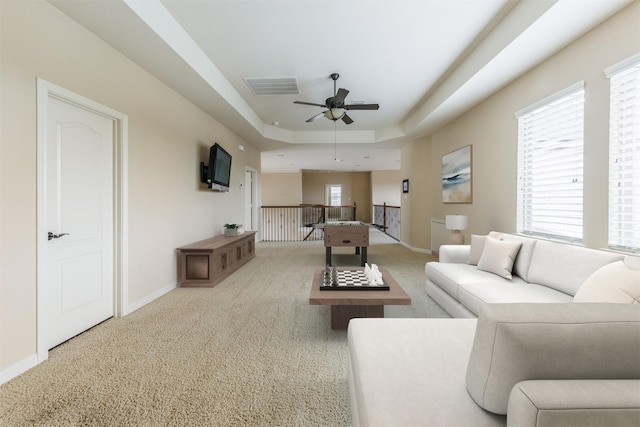 27711 Rocky Creek Ct, Fulshear, TX 77441 - carpeted living area with baseboards, visible vents, ceiling fan, and a tray ceiling