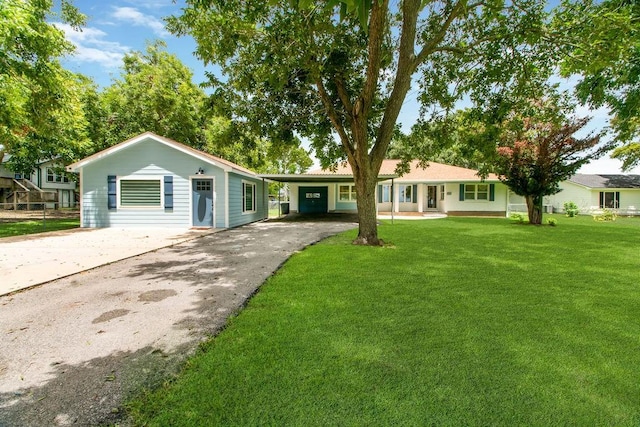 ranch-style home with an attached carport, a front lawn, and aphalt driveway