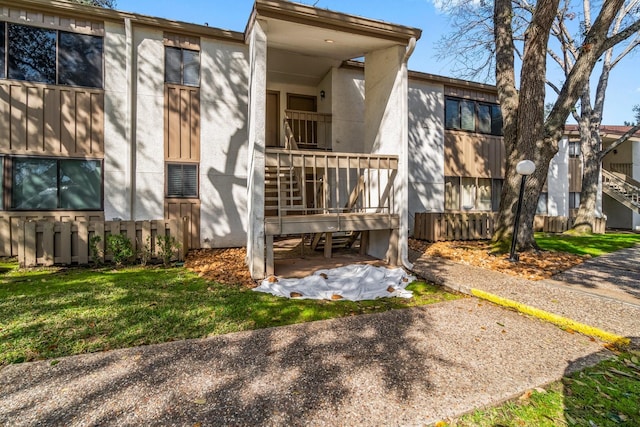 rear view of house featuring a balcony and a lawn