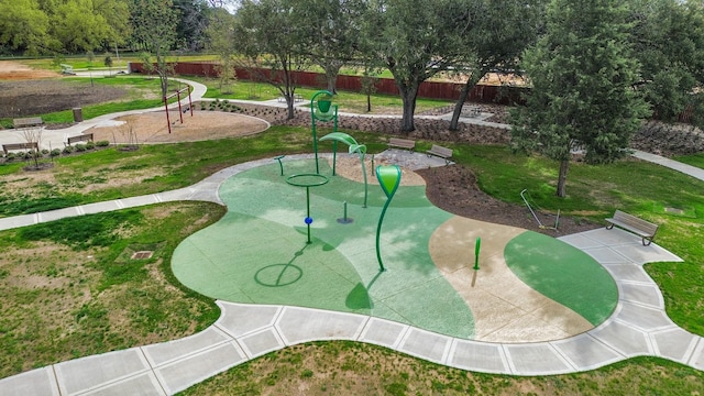 view of property's community with playground community, a yard, and fence