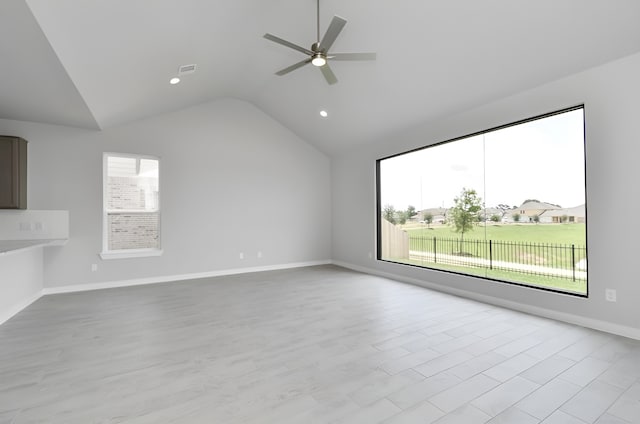 empty room with recessed lighting, light wood-style floors, vaulted ceiling, ceiling fan, and baseboards